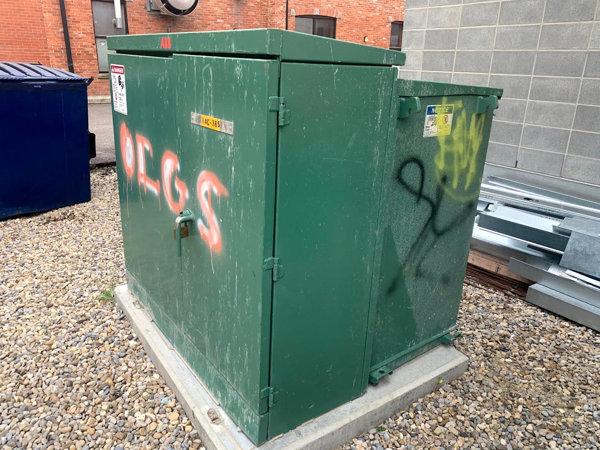 Graffiti on dark green electrical box