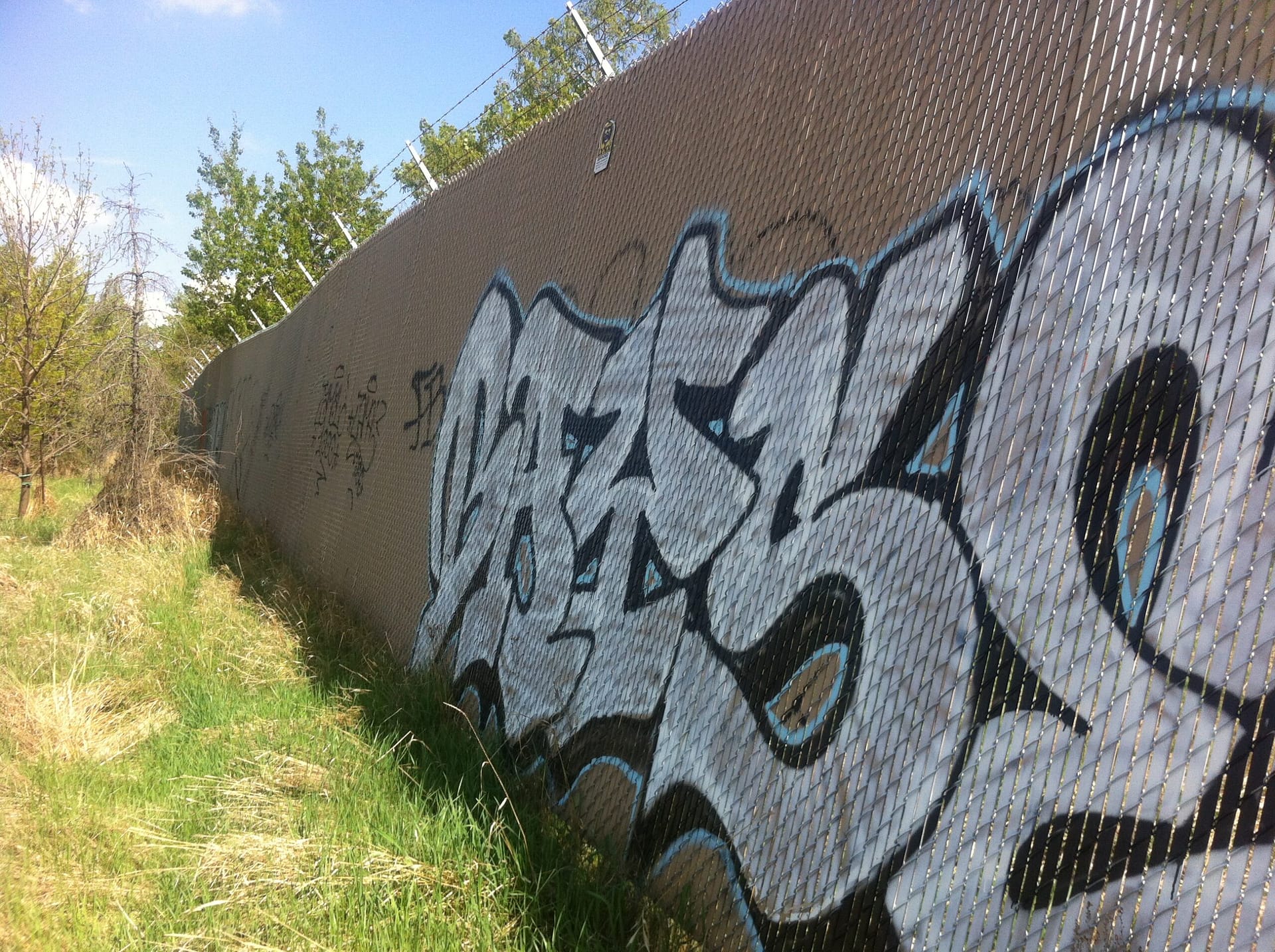 chain-link fence with privacy slats graffiti removal in Calgary 2