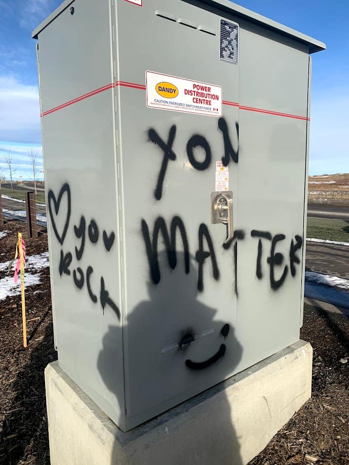 Black graffiti on grey electrical box
